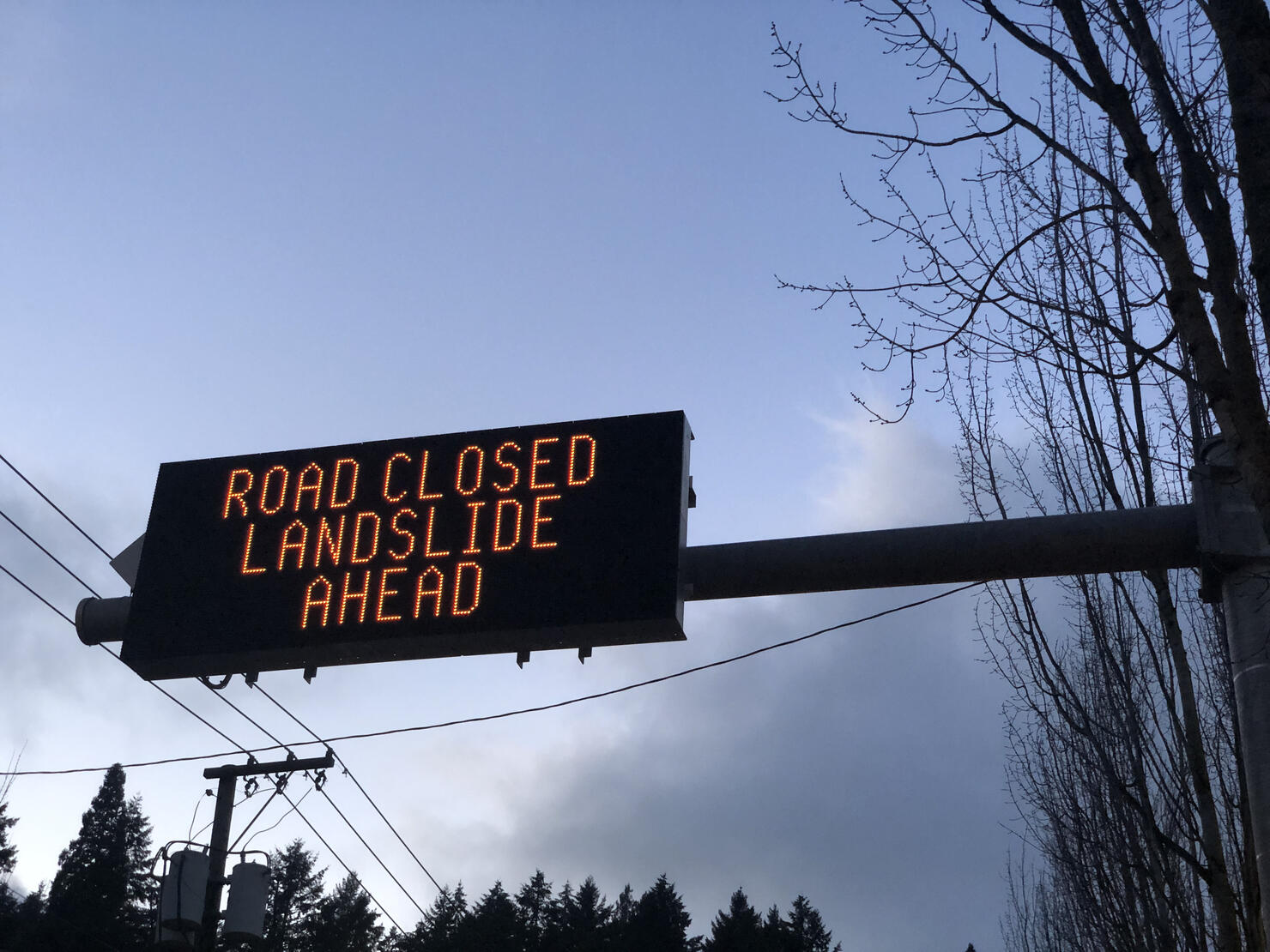 A road sign alerting drivers of a landslide ahead.