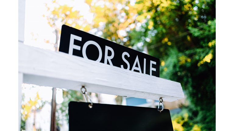 For Sale Sign in Front Yard of House