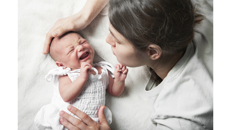 Newborn crying, sleep of children. Tired Mother with Upset Baby Suffering with Post Natal Depression