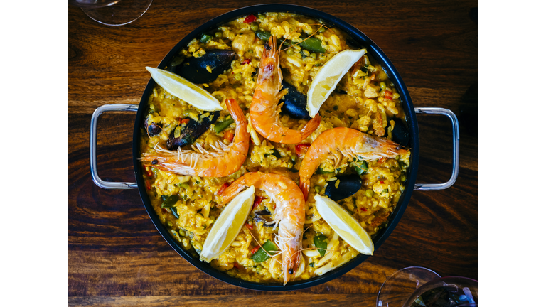 Fresh paella in pan on wooden table