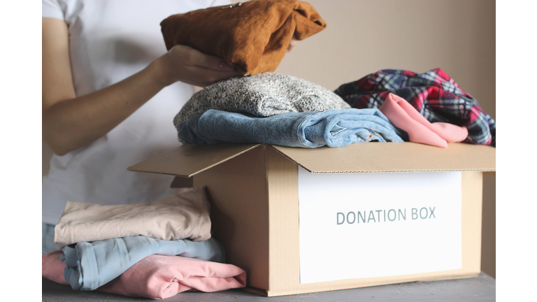 girl puts in a box with donations items. Volunteering