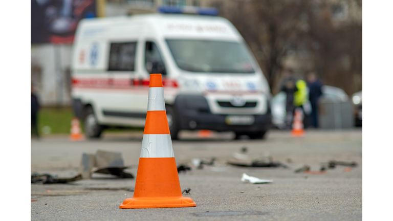 Yellow plastic cone placed on a street at car accident crash site.