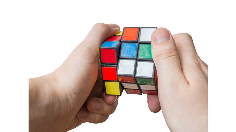 Man holds rubiks cube in hands.