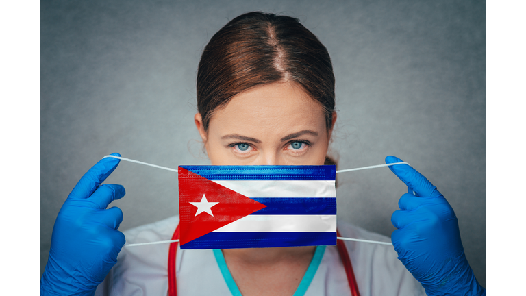 Coronavirus in Cuba Female Doctor Portrait hold protect Face surgical medical mask with Cuba National Flag. Illness, Virus Covid-19 in Cuba, concept photo