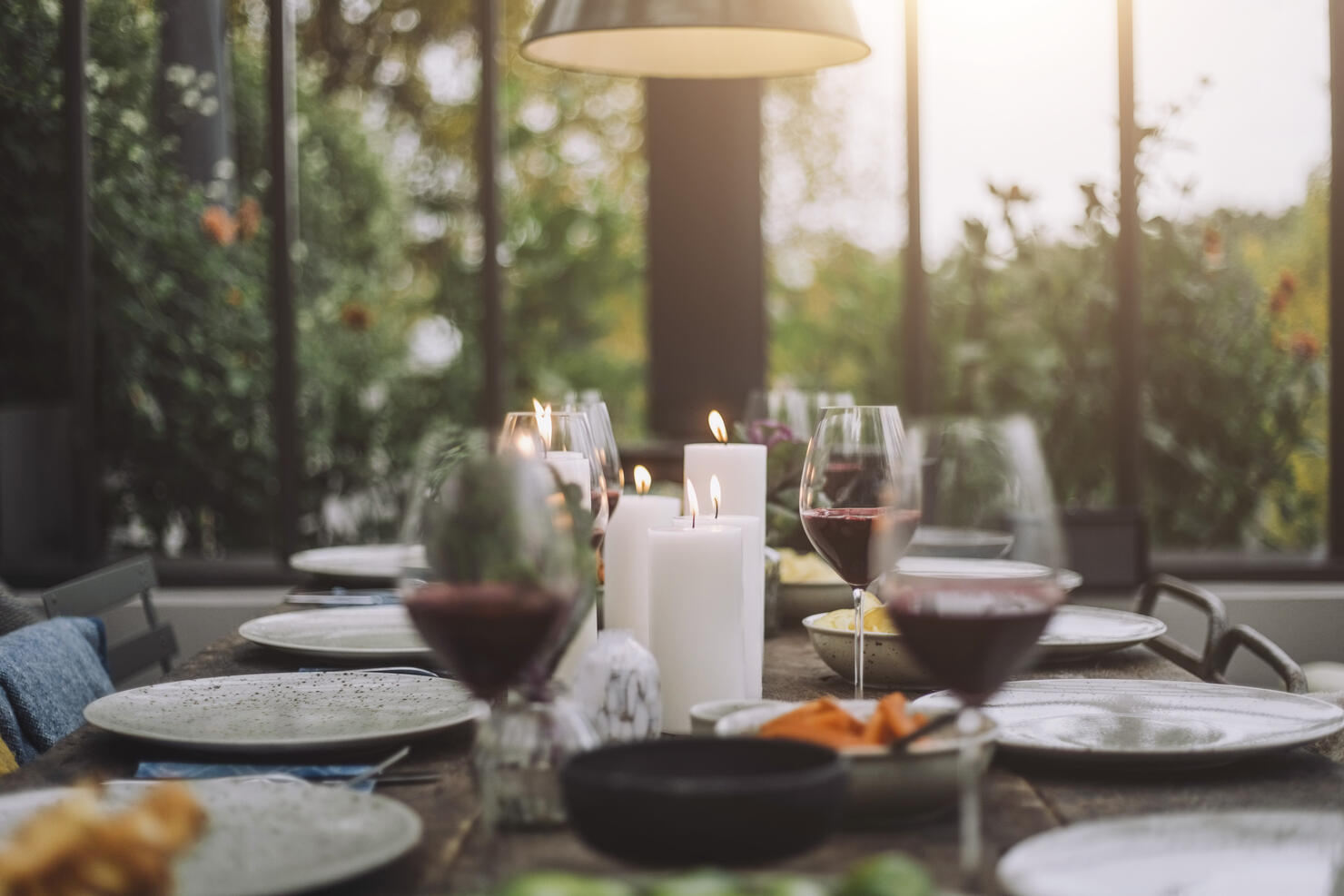 Illuminated candles with wineglasses on dining table