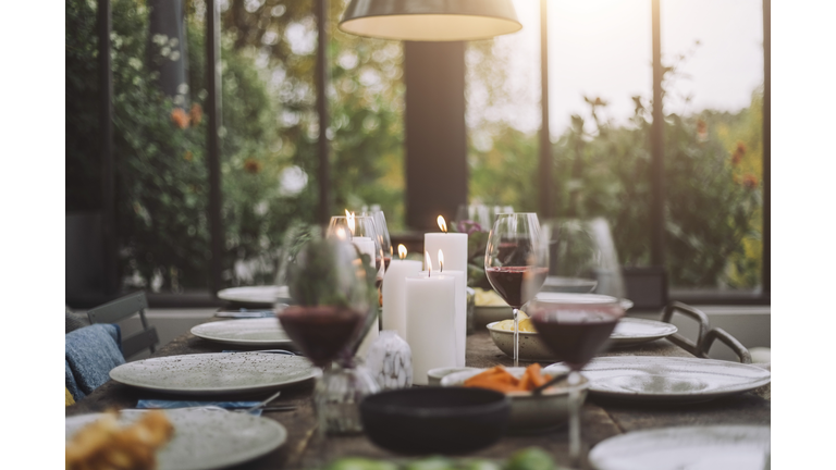 Illuminated candles with wineglasses on dining table