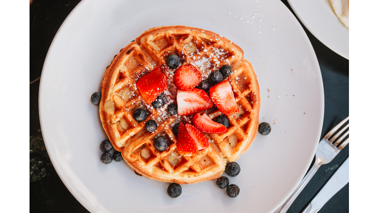 Waffles with strawberries and blueberries, directly above close-up view