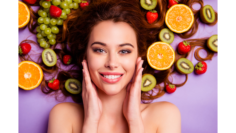 Close-up cropped portrait of nice attractive lovely well-groomed pure perfect shine cheerful cheery feminine wavy-haired lady touching smooth clean clear skin isolated over violet purple background