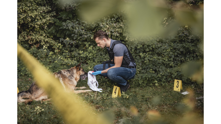 Crime Scene Investigator and Police Dog in Woodland Area