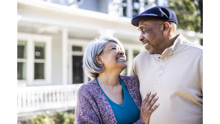 Portrait of senior couple in front of suburban home