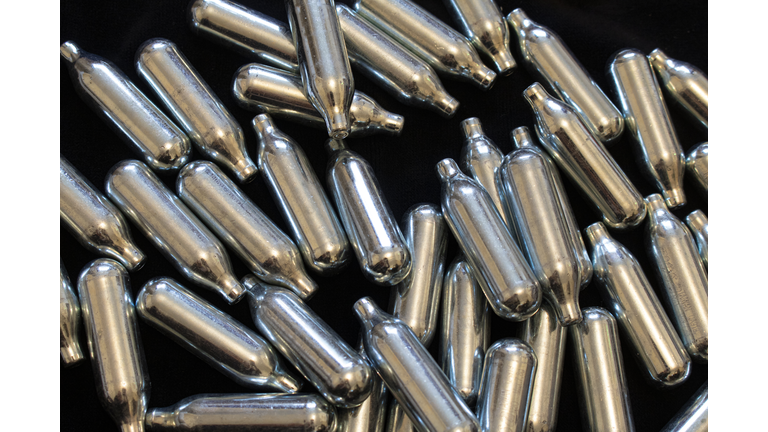 Nitrous Oxide Metal Bulb Canisters Recreational Drugs on Black Background