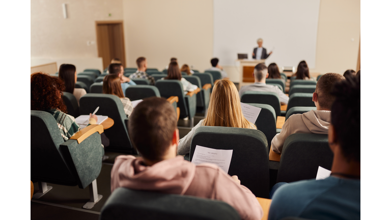 Rear view of large group of students on a class at lecture hall.