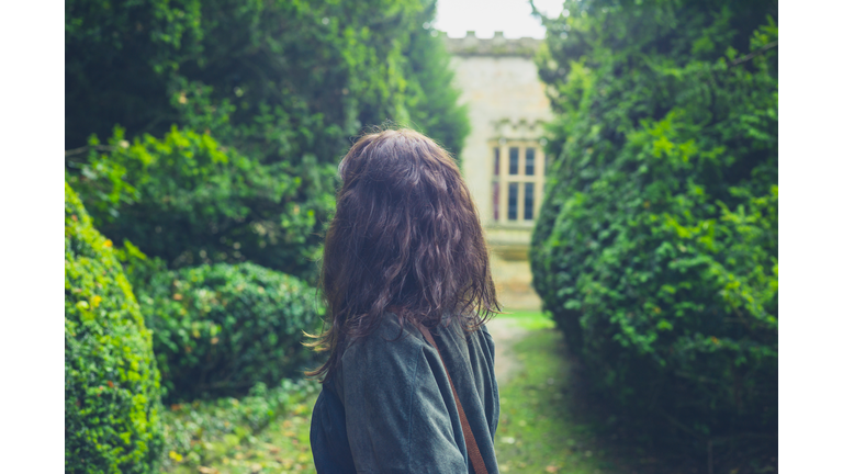 Young woman exploring formal garden