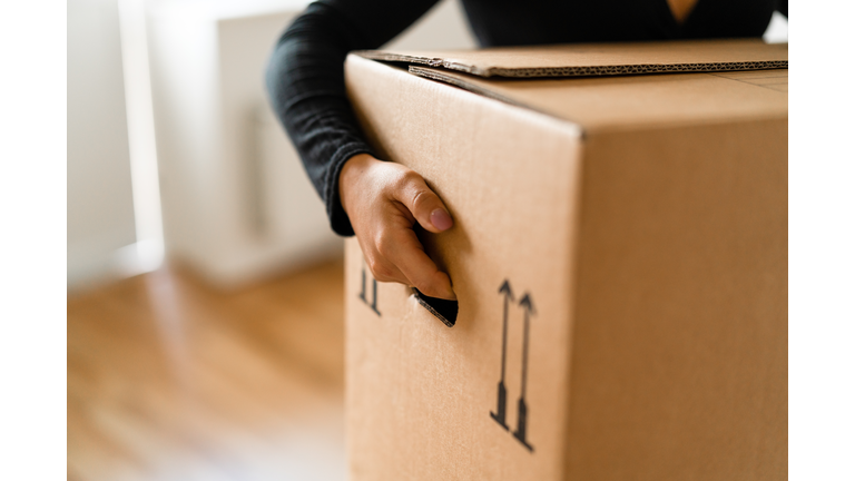 Woman carrying boxes into her new home