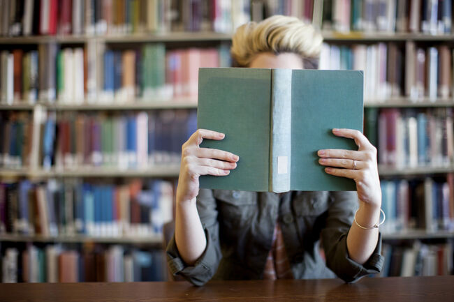 Woman reading book in library