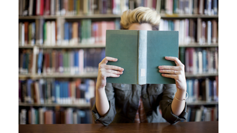 Woman reading book in library