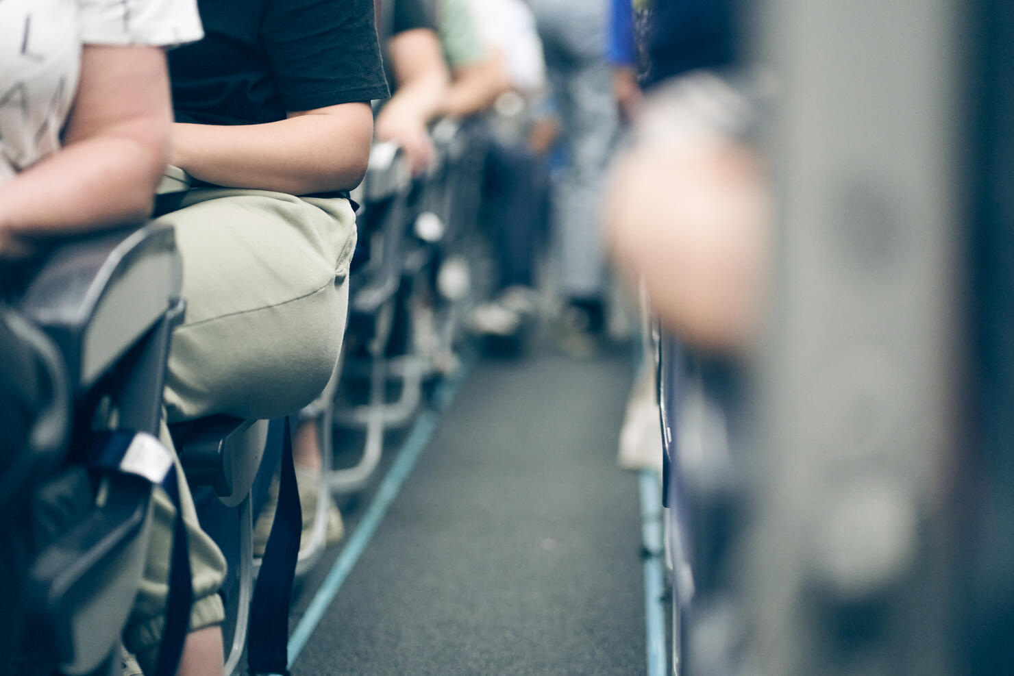 The aisle on the plane, people sitting in their seats, selective focus, lifestyle photo.