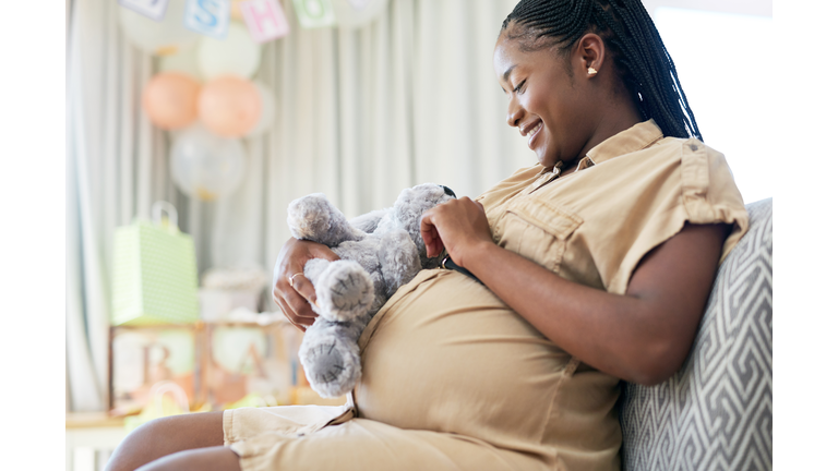 Shot of a young mother to be holding a soft toy meant for her child