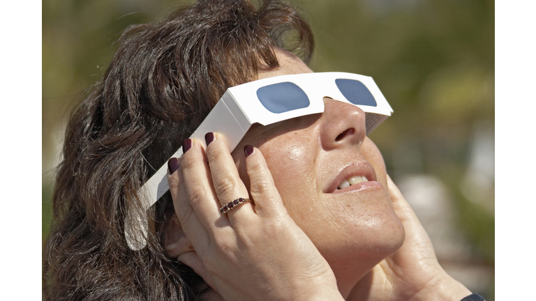 Woman with solar glasses looking at sun