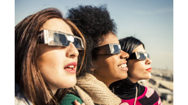 Group of friends looking to a solar eclipse