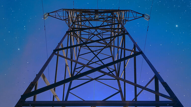 Transmission tower (power towers or electricity pylon) against blue sky at night