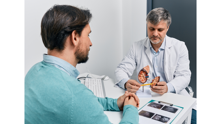 Adult man during consultation with experienced urologist about his kidney disease and treatment at medical clinic. Kidneys health