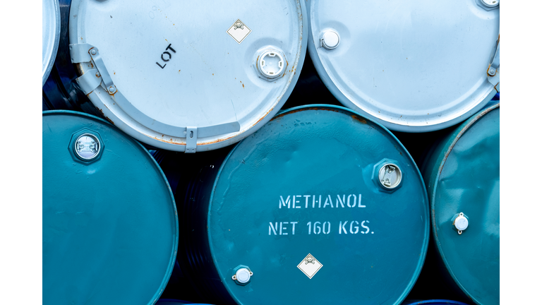 Old chemical barrels. Stack of blue methanol or methyl alcohol drum. Steel chemical tank. Toxic waste. Chemical barrel with toxic warning symbol. Industrial waste in drum. Hazard waste storage.