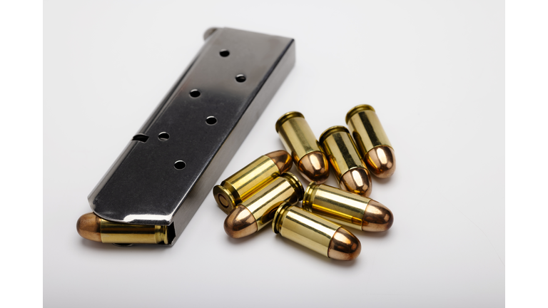 .45 ACP bullets with gun magazine on white background
