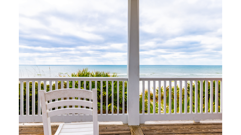 Seaside, Florida white wooden gazebo pavilion architecture with Gulf of Mexico ocean waterfront beach view, chair by railing