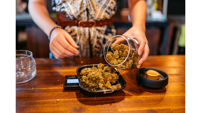 Young Woman Weighing Herbal Cannabis On A Scale In A Cannabis Shop In Thailand