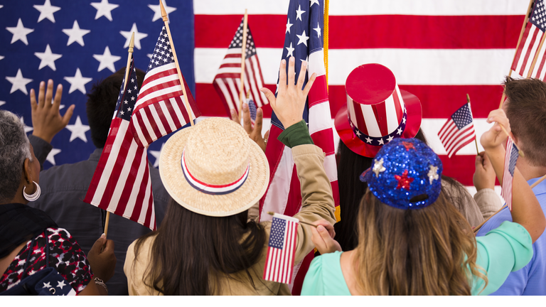 American people wave flags at political rally. USA.