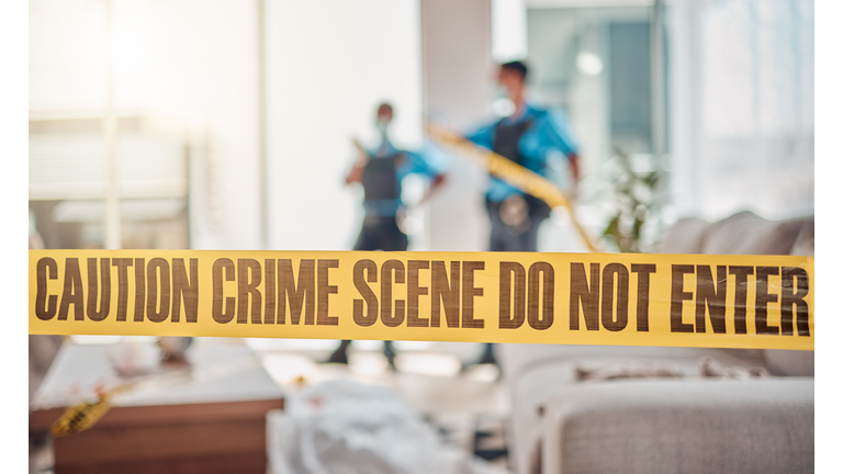 Tape, crime scene and police in house for investigation, inspection and forensic analysis. Law enforcement, safety and security people in living room for criminal, murder and searching for evidence