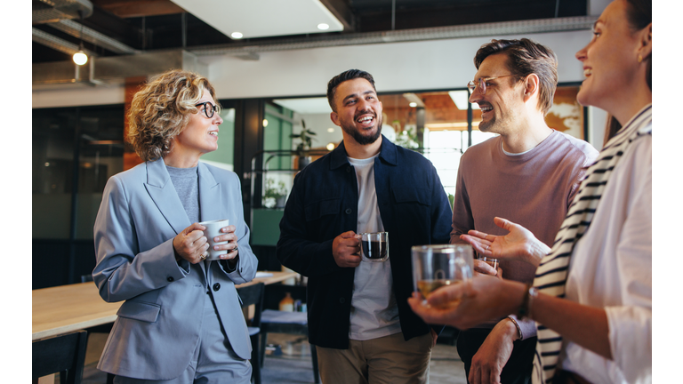 Happy colleagues having a coffee break in an office