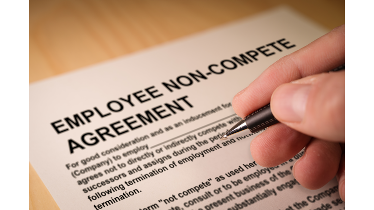 Man signing an employee Non-compete agreement