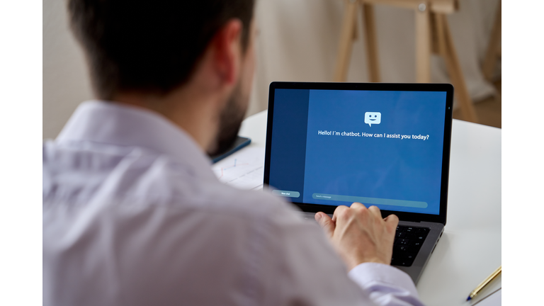 Unrecognizable man talking to a virtual chat assistant