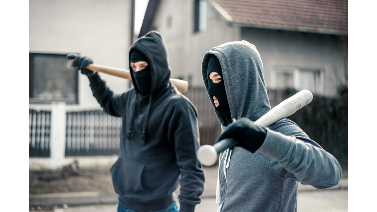 Young men holding a baseball bat symbolizing crime