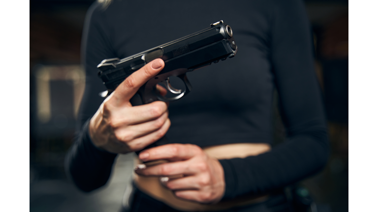 Female preparing for a shooting drill indoors