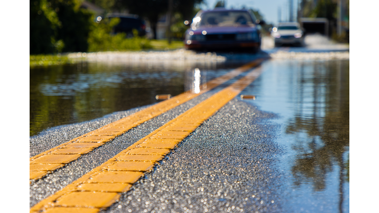 Car driving through flooded road after storm