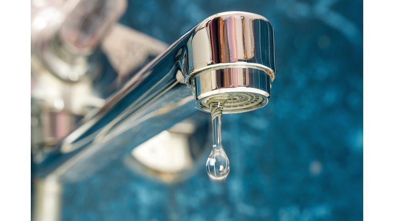 A drop of water drips from a leaky faucet