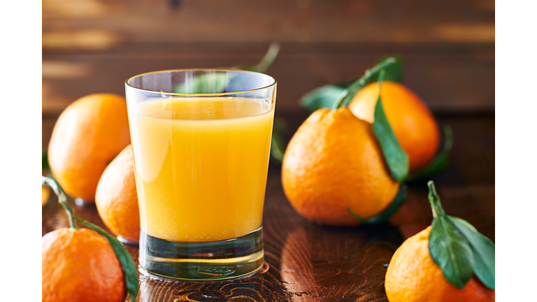 fresh glass of orange juice on rustic table top