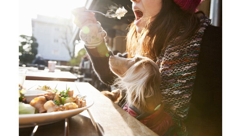 woman and dog sitting on the patio at cafe