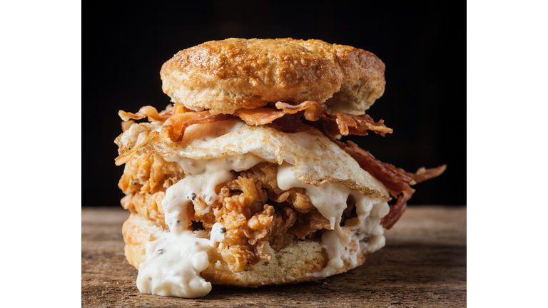 Buttermilk biscuit and fried chicken breast sandwich with a fried egg and bacon