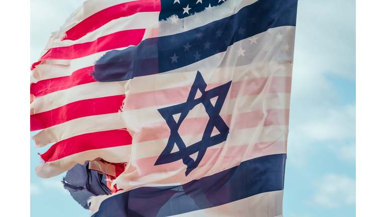 Ragged National flags of Israel and USA waving