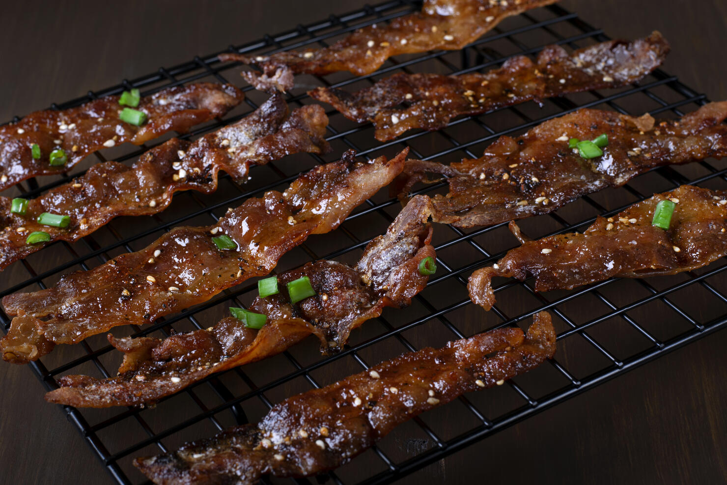 Roasted bacon in sweet maple syrup glazing topped with sesame seeds and herbs