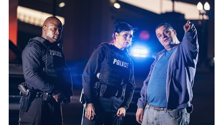 Two police officers talking with a witness or victim