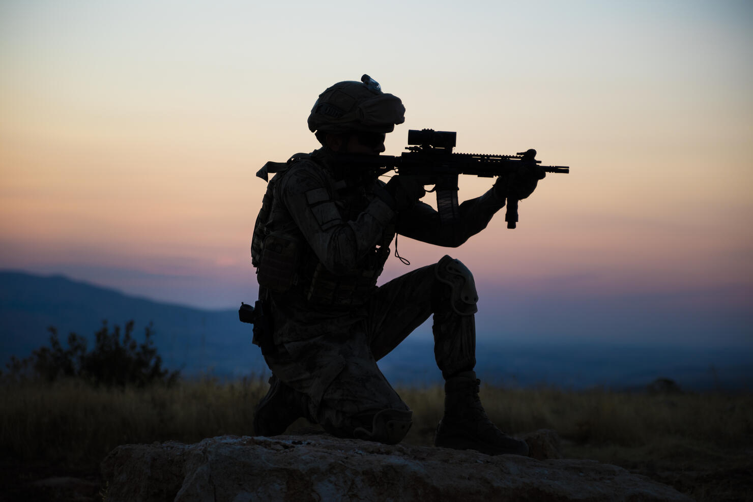 Silhouette of an kneeling Turkish soldier shooting at target at sunset