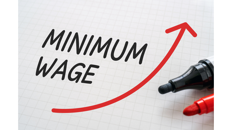 White paper written "MINIMUM WAGE" with markers.