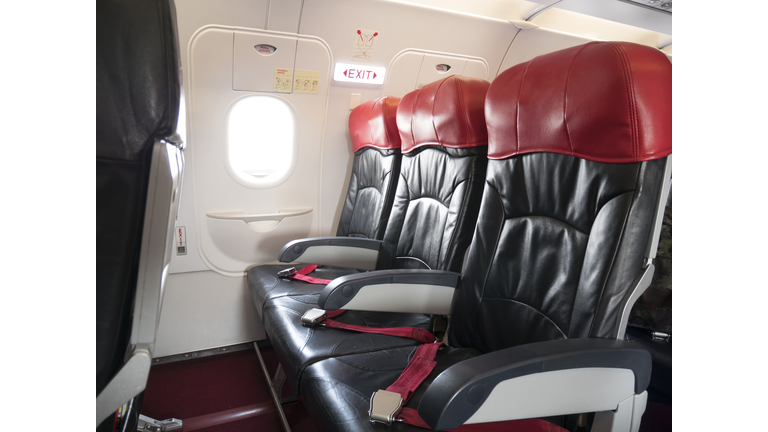 Airplane flight safety concept : emergency exit seat row in airplane , exit sign light over plane emergency exit door turn on for passenger.