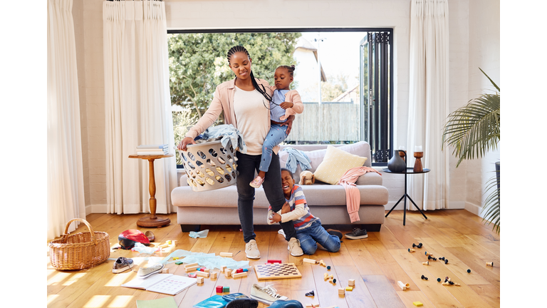 Shot of a little boy throwing a tantrum while holding his mother's leg at home