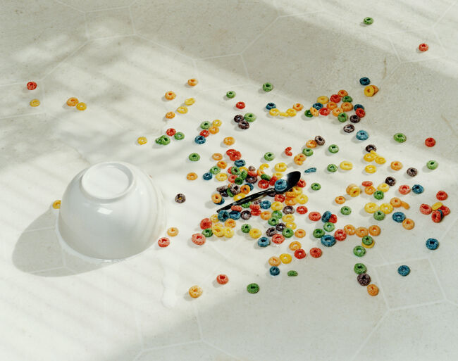 Spilt bowl of cereal on white floor